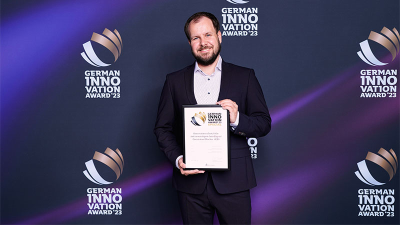 Ein EXCOR Mitarbeiter hält stolz den Innovation Award hoch